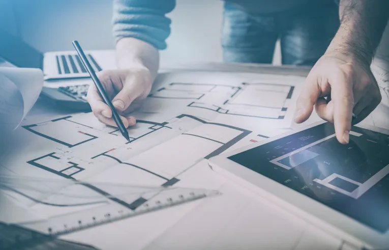 Worker looking at printed and in-tablet building plans