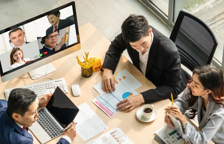 Pracownicy podczas hybrydowego spotkania w biurze