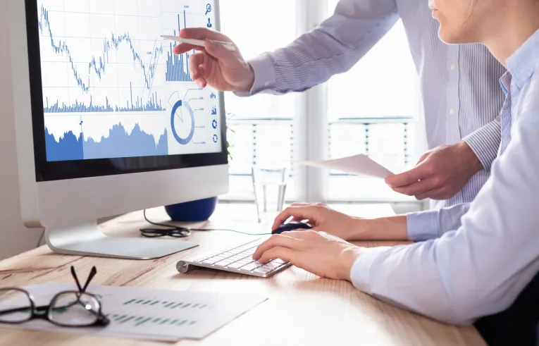 Ludzie analizujący wykresy na ekranie komputera