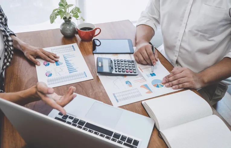 Dwie osoby przy biurku omawiające dokumenty