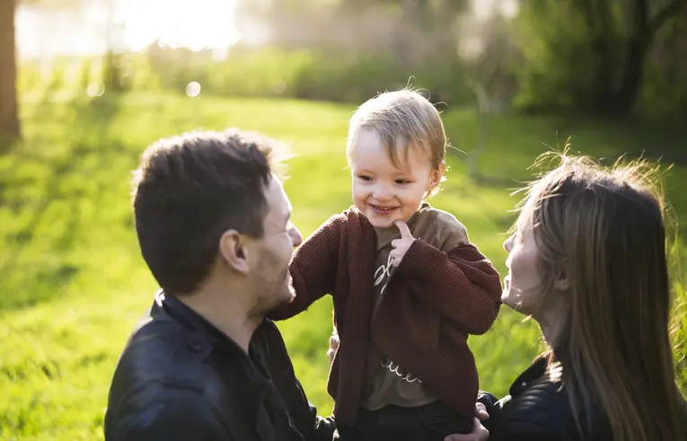 aA child surrounded by their parents